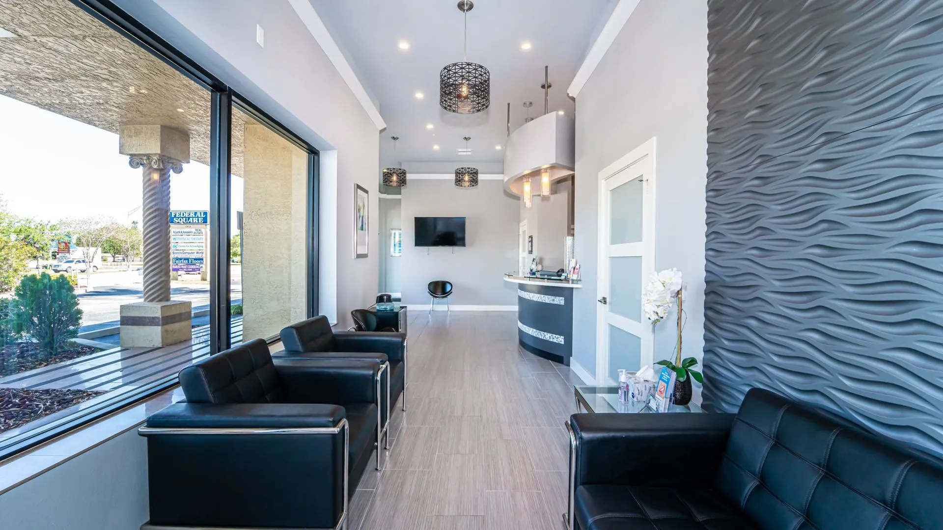 Patient waiting area with large windows and black seating