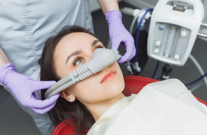 Patient relaxing in a dental chair while receiving nitrous oxide sedation